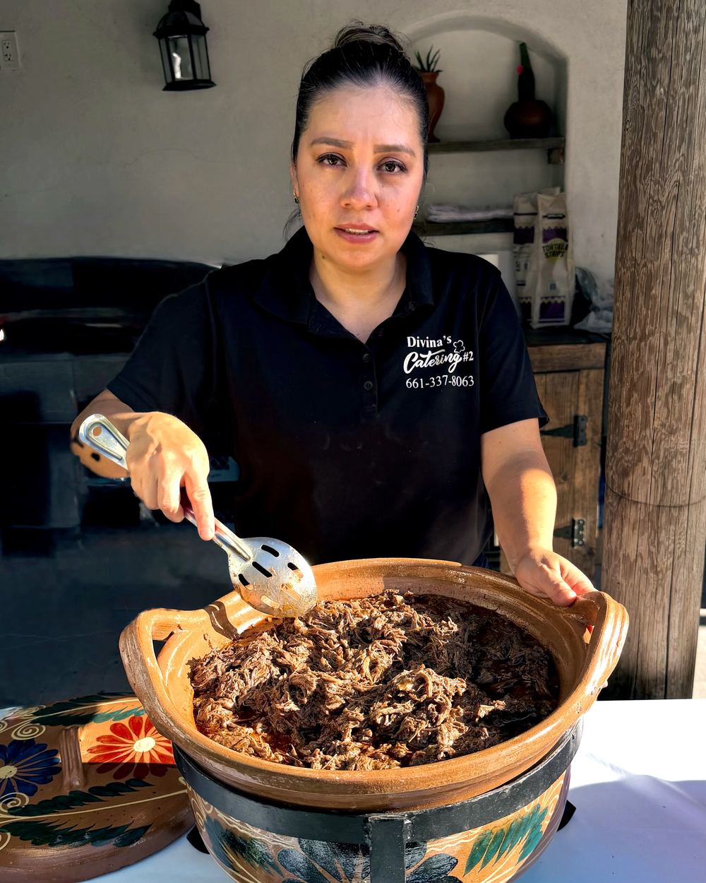 Beatriz González serving barbacoa from a clay cazuela