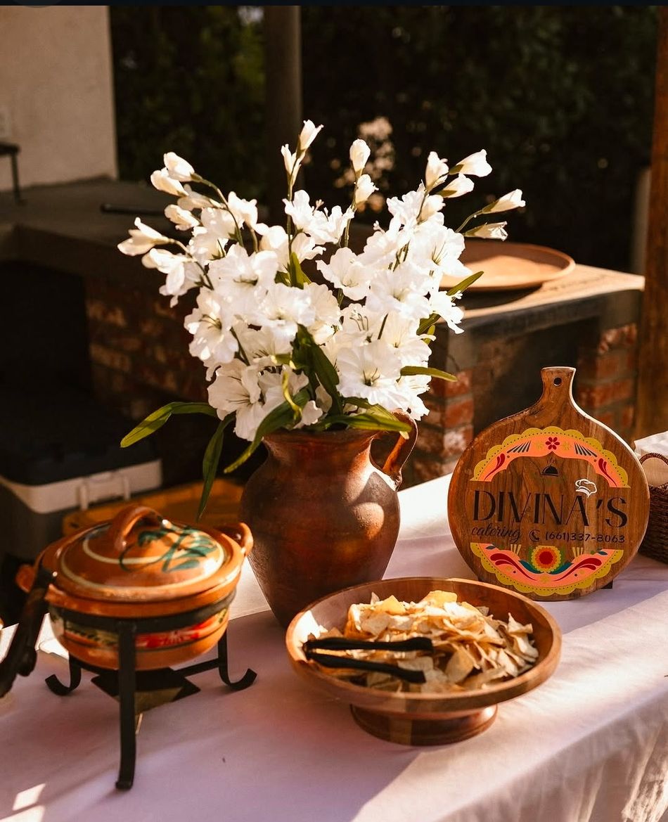Divina's Catering board beside white flowers